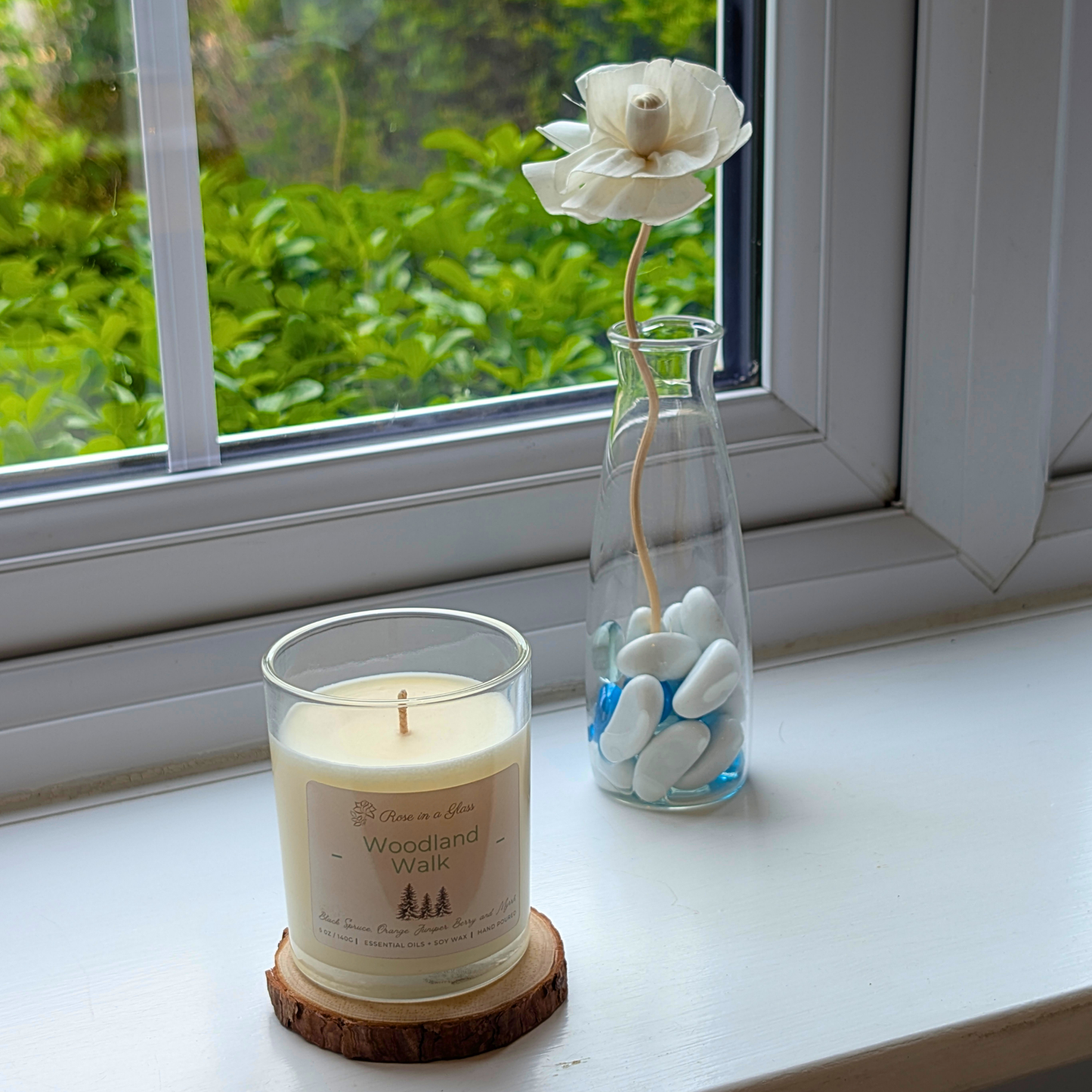 Woodland Walk aromatherapy candle on a windowsill wood slice for a neurodiversity friendly aromatherapy reset