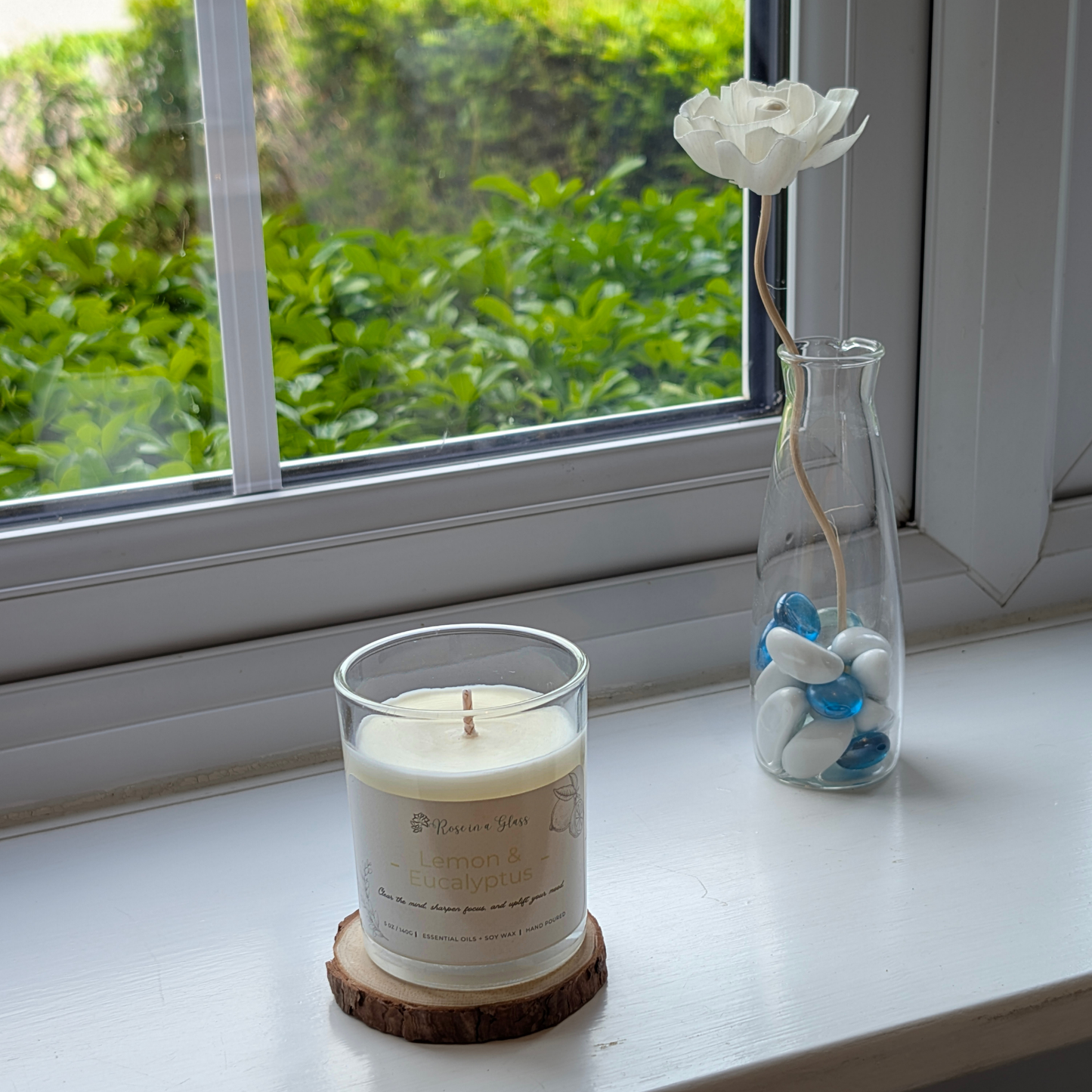Lemon and Eucalyptus candle on a windowsill wood slice for a neurodiversity friendly aromatherapy reset