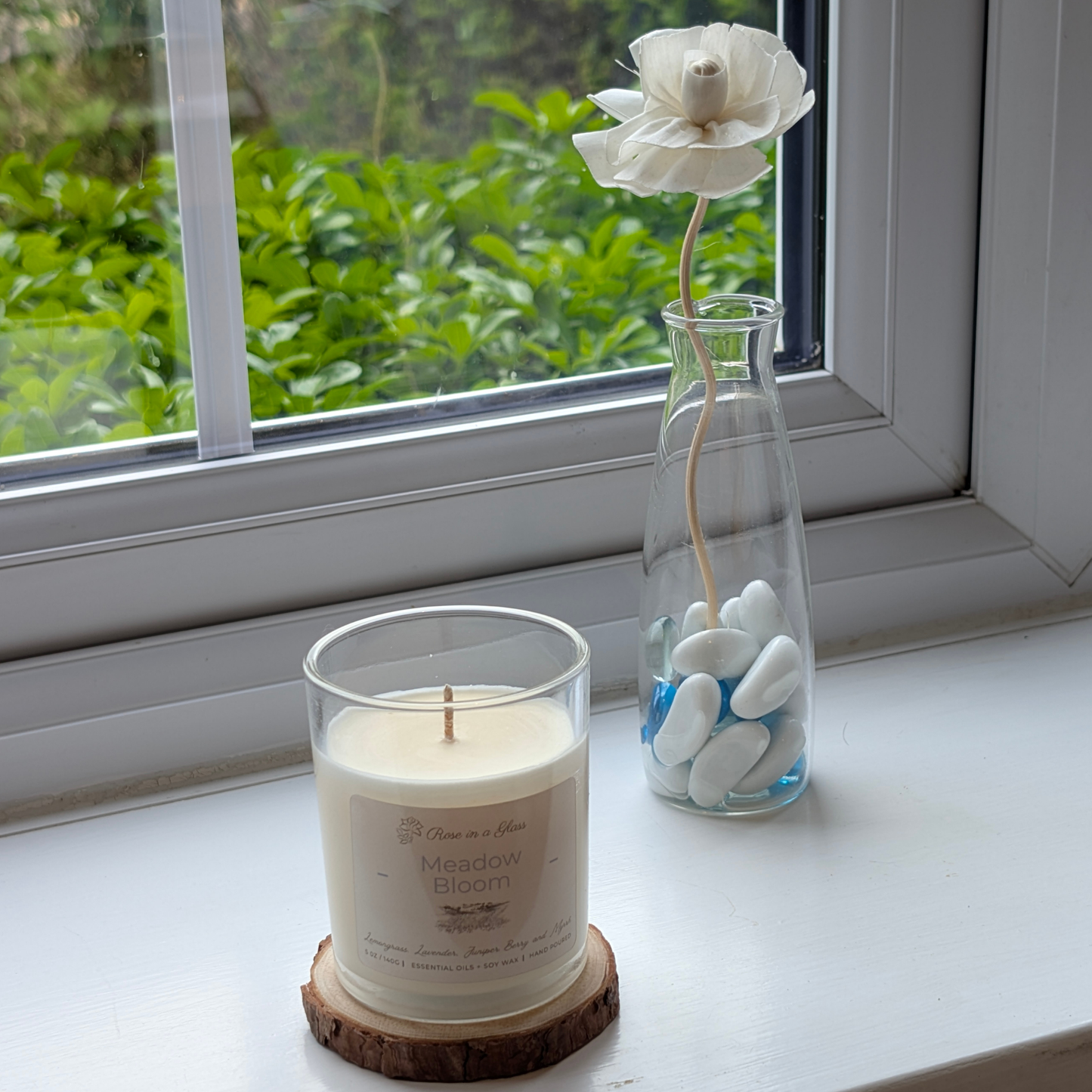 Meadow Bloom candle on a windowsill wood slice for a neurodiversity friendly aromatherapy reset