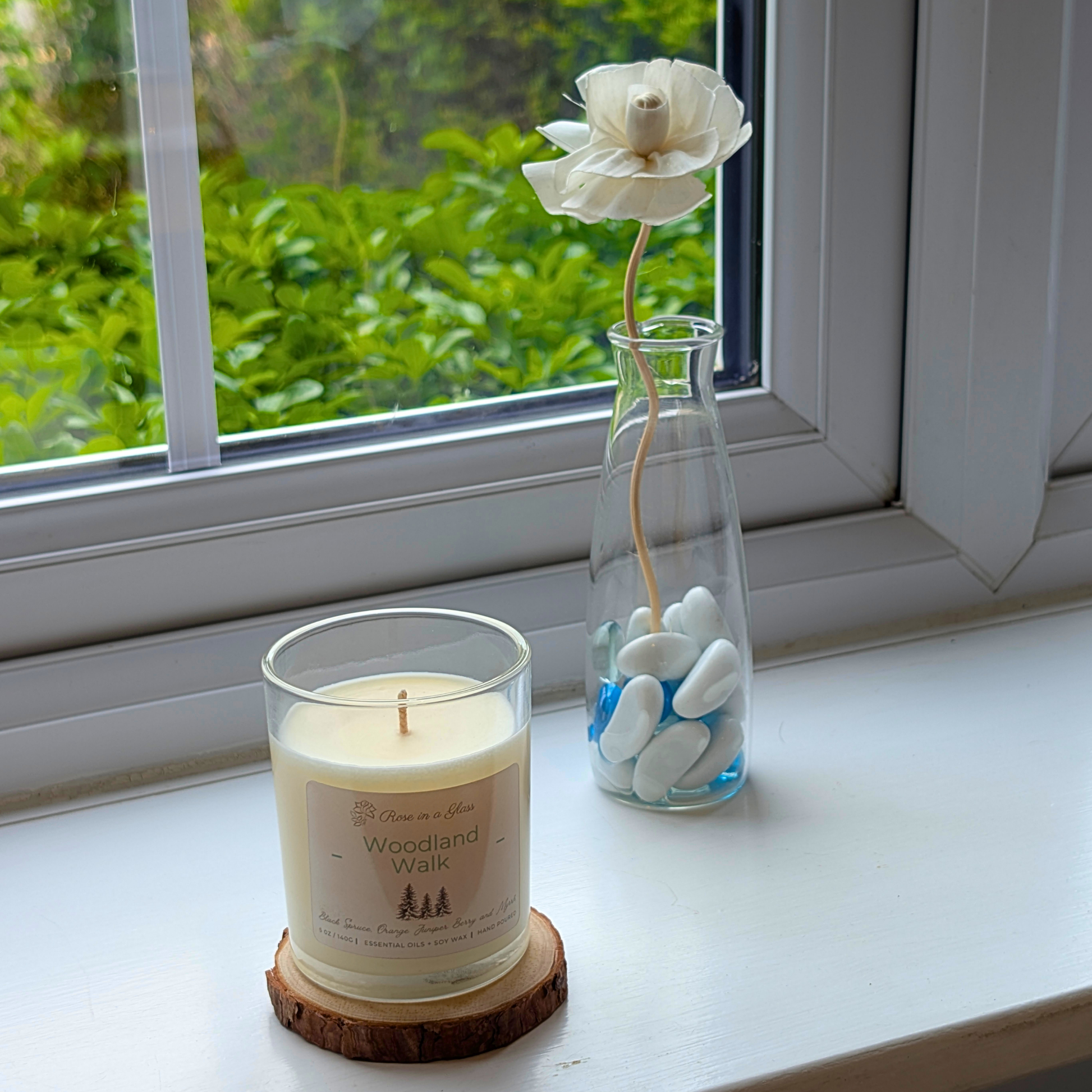 Woodland Walk aromatherapy candle on a windowsill wood slice for a neurodiversity friendly aromatherapy reset