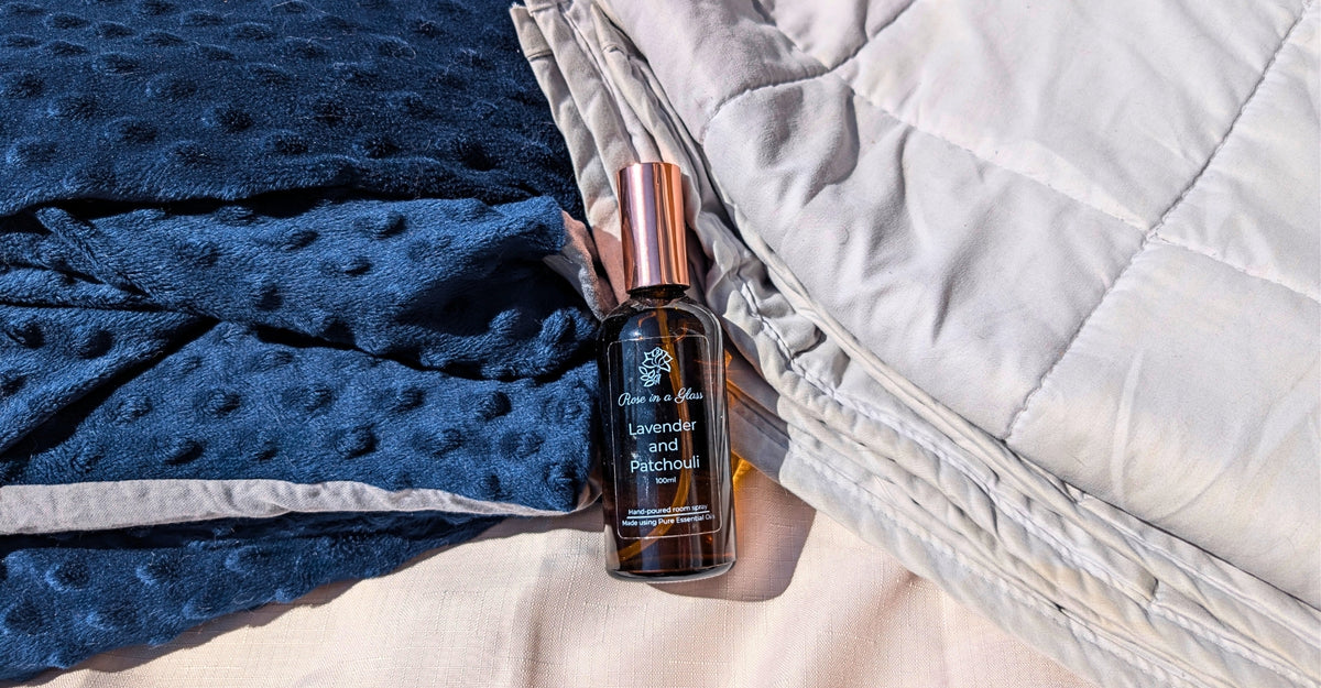 A bottle of Lavender and patchoili Room Spray by Rose in a Glass placed between two different anxiety blankets