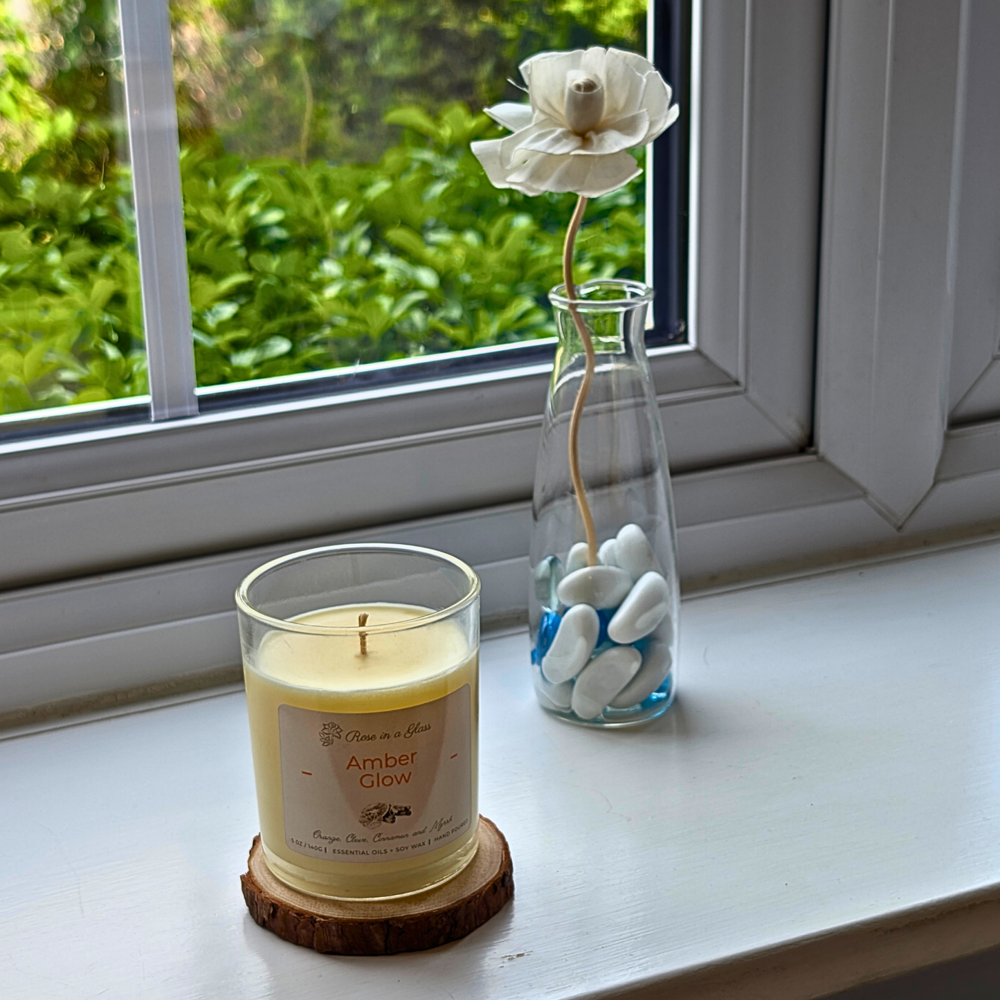 Amber Glow aromatherapy candle on a windowsill wood slice for a neurodiversity friendly aromatherapy reset