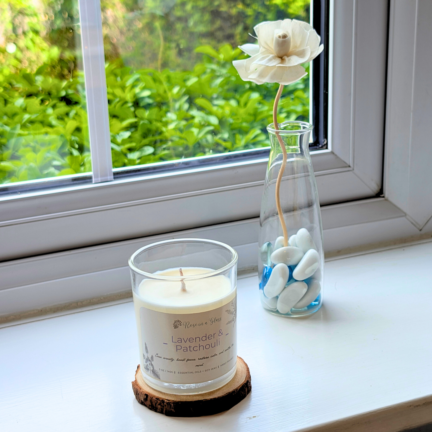 Lavender and Patchouli candle on a windowsill wood slice for a neurodiversity friendly aromatherapy reset