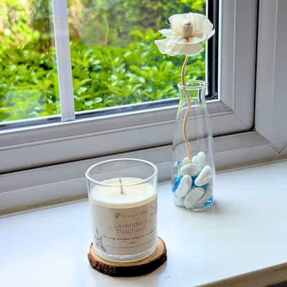 Lavender and Patchouli candle on a windowsill wood slice for a neurodiversity friendly aromatherapy reset
