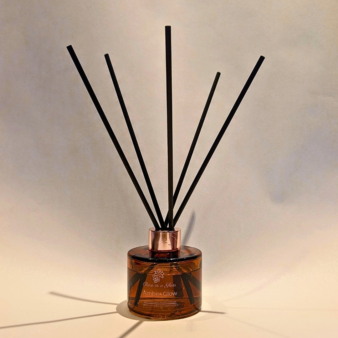 Botanical Amber Glow reed diffuser with black fibre reeds for continuous aromatherapy wellness and busy mind sensory support
