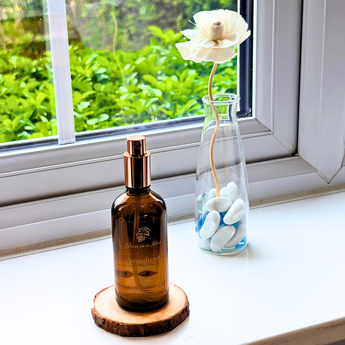 Woodland Walk Aromatherapy room spray on a windowsill with a rose diffuser for a tranquil home environment